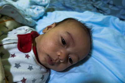 Portrait of cute baby lying on bed