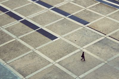 Rear view of woman walking on tiled floor