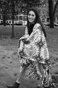 Portrait of young woman with shawl walking at park