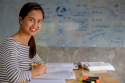 Portrait of smiling woman studying at table