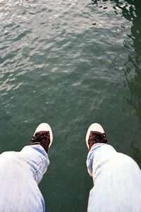 Low section of man standing in water