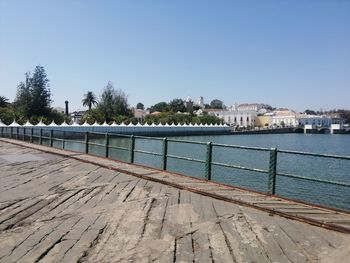 View of footpath by river against clear sky