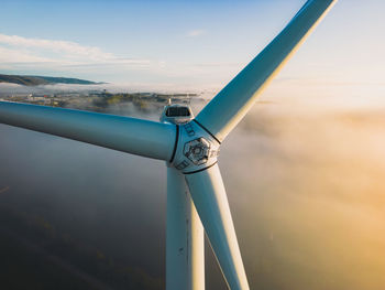 Close-up on the propellers of a wind turbine during a misty morning and sunrise. green energy. 