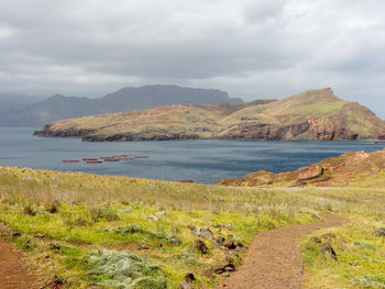 Scenic view of sea and mountains against sky