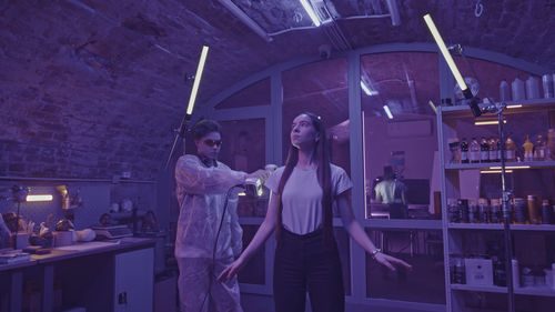 Portrait of young woman standing against wall