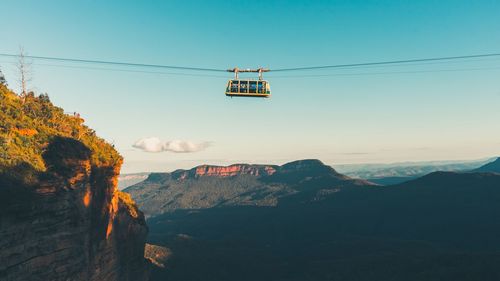 Low angle view of overhead cable car against sky