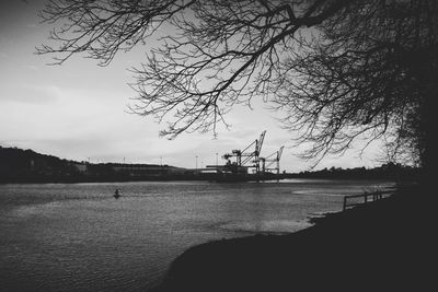 Scenic view of silhouette harbor against sky in city