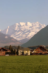 Scenic view of field and mountains against sky