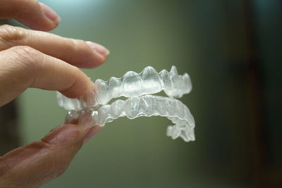 Close-up of hand holding dentures