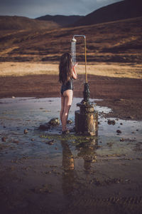 Woman holding water splashing in lake