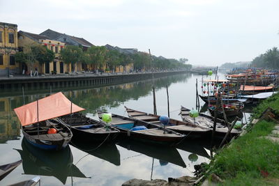 Boats moored in river against sky