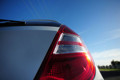 Close-up of car tail light against sky