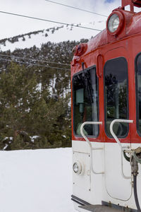 Red train on snow covered land