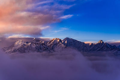 Scenic view of snowcapped mountains against sky during sunset