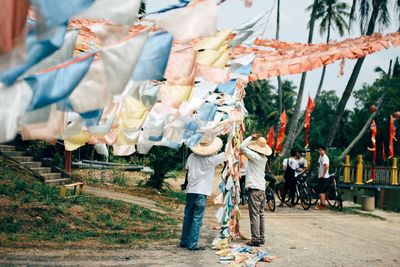 Rear view of men hanging pennant banners