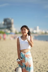 Portrait of young woman standing on beach