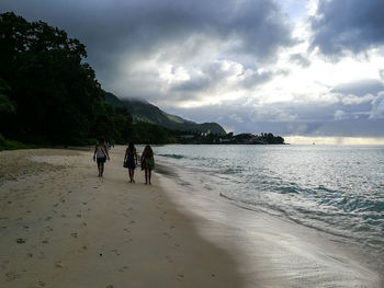 People walking on beach against sky