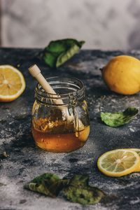 High angle view of fruits and honey in jar on table