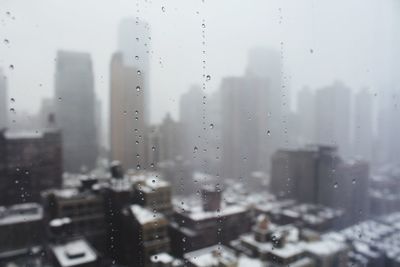 City seen through wet window in rainy season