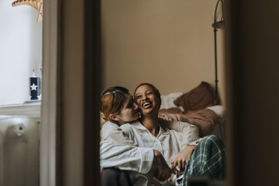 Romantic non-binary couple spending leisure time in bedroom at home