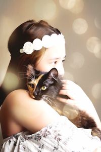 Close-up of girl holding cat outdoors