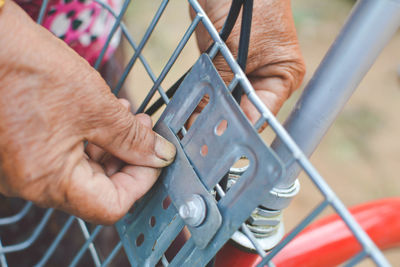 Close-up of cropped hand fixing bicycle basket