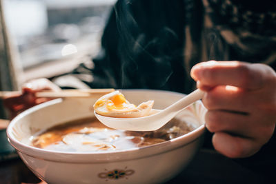 Cropped hand having soup at home