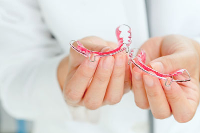 Close-up of dentist holding braces