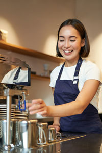 Portrait of smiling young woman sitting at home