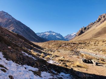 Scenic view of snowcapped mountains against clear blue sky