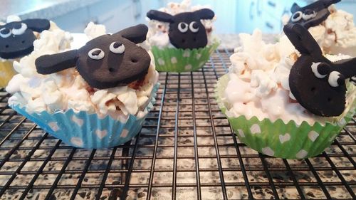 Close-up of sheep shape cupcakes metal grate