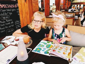 Portrait of happy girl sitting on table