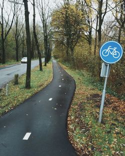 Empty road with trees in background