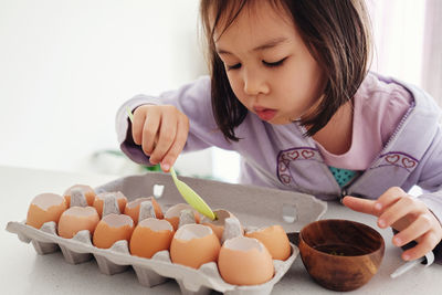 Close-up of girl putting mud in eggs shells
