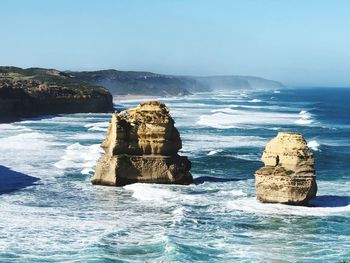 Rock formation in sea against sky