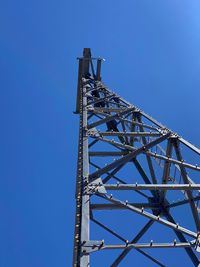 Low angle view of communications tower against clear blue sky