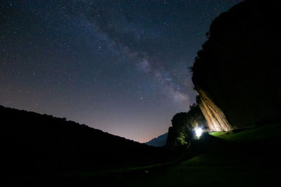 Low angle view of silhouette mountain against sky at night