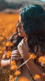 Young woman with long hair standing amidst plants