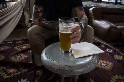 Low section of man holding beer glass