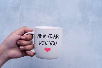 Close-up of hand holding coffee cup