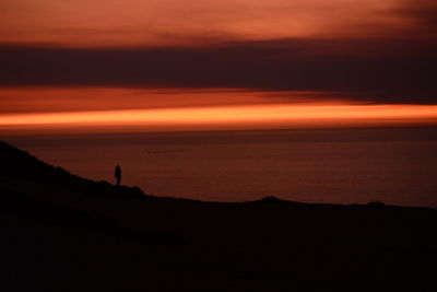 Silhouette of man standing on coast