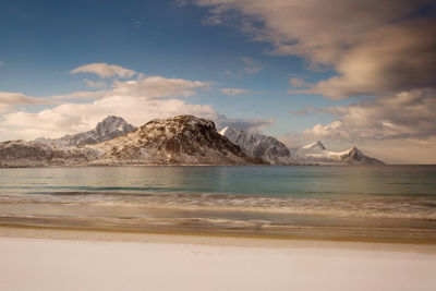 Scenic view of sea and mountains against sky