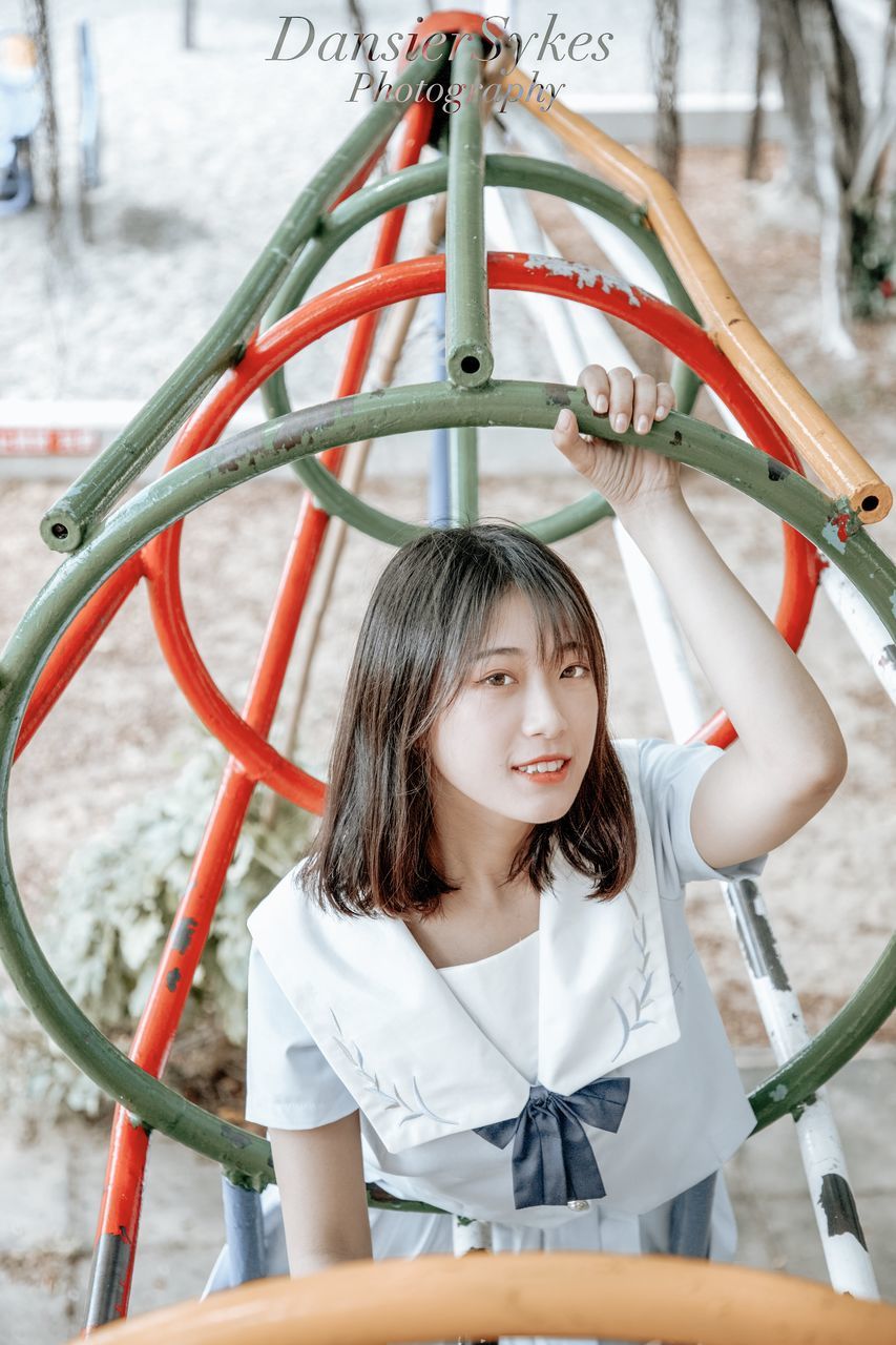 one person, childhood, real people, portrait, smiling, happiness, front view, women, leisure activity, lifestyles, looking at camera, child, emotion, girls, hair, hairstyle, playground, innocence, outdoor play equipment, bangs