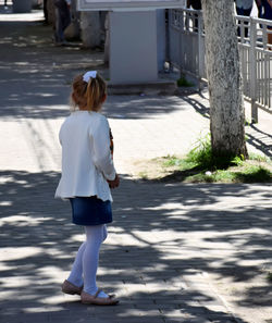 Woman standing on footpath