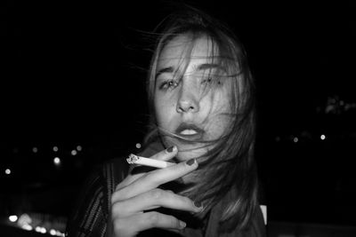 Portrait of woman smoking cigarette at night