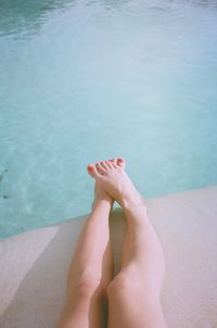 Low section of woman relaxing in swimming pool