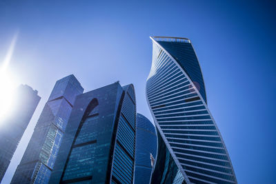 Low angle view of modern buildings against clear blue sky