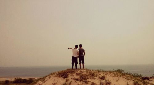 Rear view of people standing on beach