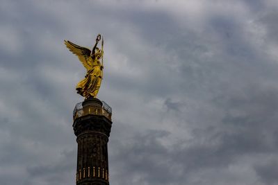 Low angle view of statue of liberty against cloudy sky