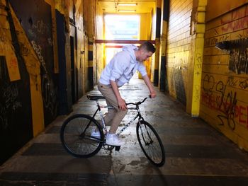 Young man riding bicycle in garage